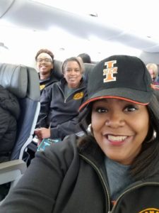 Lisa Givan selfie with spring break crew behind her on the plane
