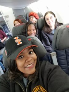 Lisa Givan selfie with spring break crew behind her on the plane